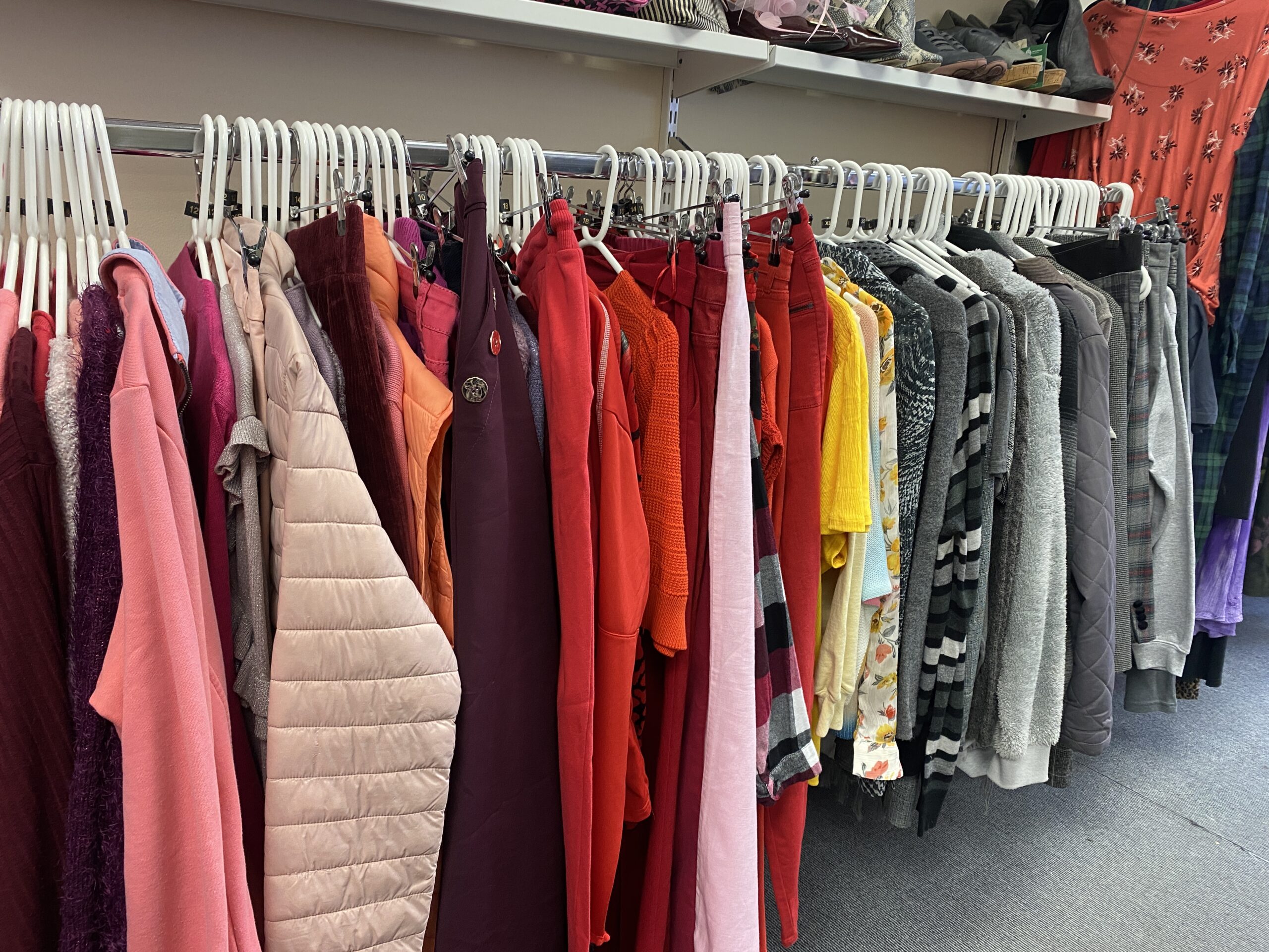 Hanging rail of various coloured garments.