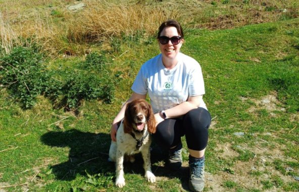 Spaniel with owner in a field on a hot, sunny day.