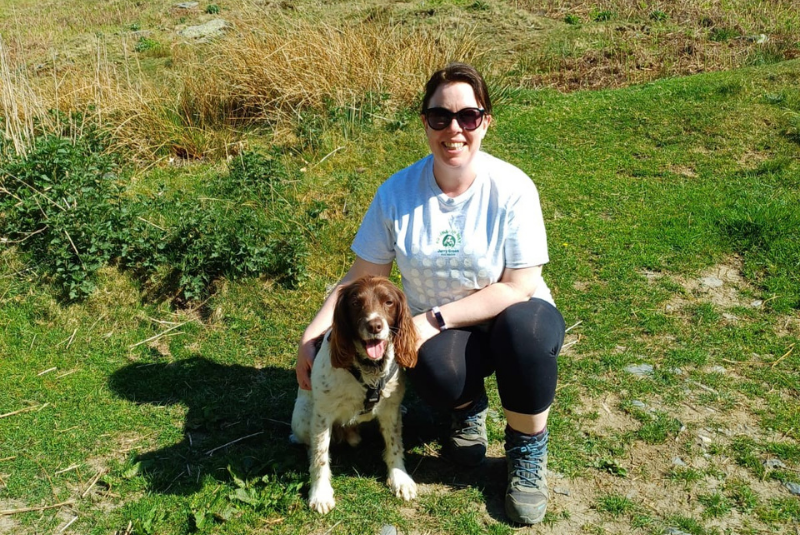 Spaniel with owner in a field on a hot, sunny day.