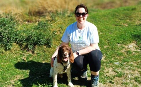 Woman crouched down with Spaniel dog wearing Jerry Green Dog Rescue 60 Miles in May tshirt
