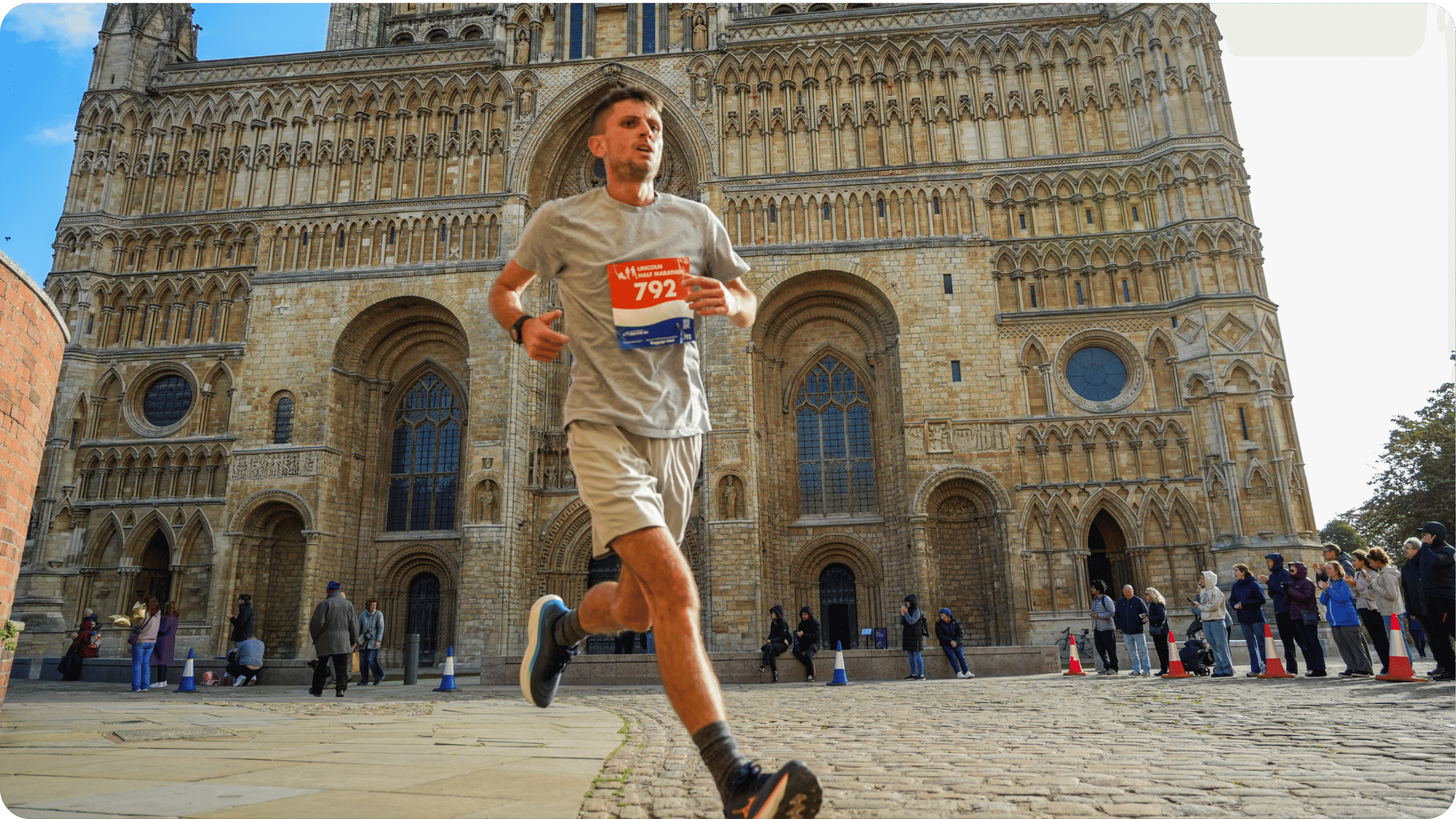 Young man running Lincoln Half Marathon in front of Lincoln Cathedral