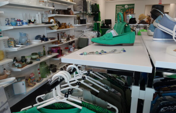 Inside of shop showing clothes hanging and shelves lined with products