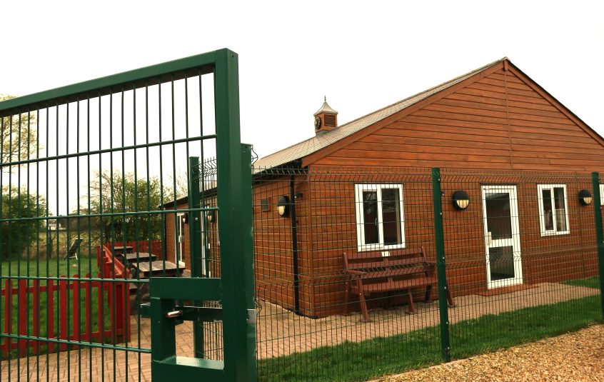 Building behind green metal gates.