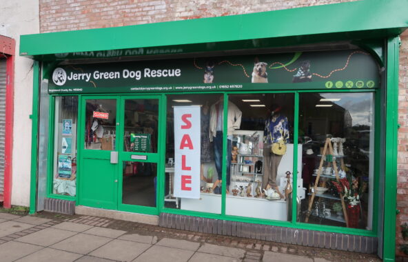 Frontage of Jerry Green Dog Rescue charity shop with large Sale notice in window.