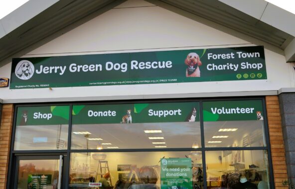 Shop front window with shop fascia saying Jerry Green Dog Rescue Forest Town Charity Shop. Decals under the fascia saying shop, donate, support, volunteer