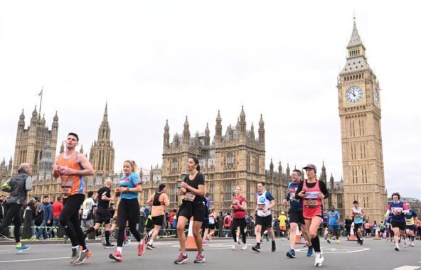 Marathon runners in London running past Houses of Parliament with Big Ben in the background.