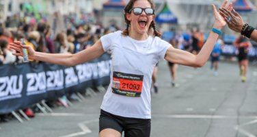 Image of person running the Brighton Marathon, high fiving the crowd